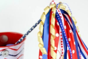Red, white and blue ribbon attached to a wand sticking out of a bucket
